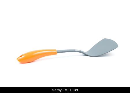 Grey plastic kitchen spatula with orange handle isolated on white background, surface. Kitchen accessory. Stock Photo