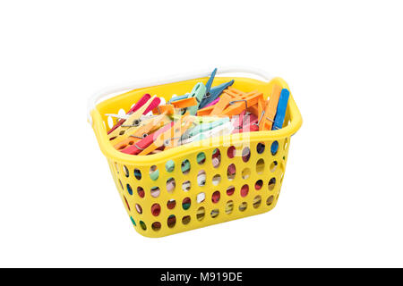 Pile of colourful plastic cloth clamps inside yellow basket isolated on white background.. Path saved Stock Photo