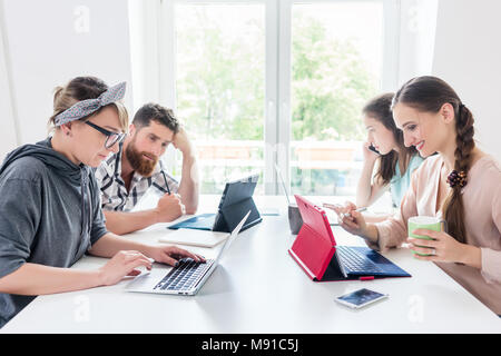 Dedicated young woman editing a document in a modern office space Stock Photo