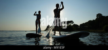 Family Having Fun Stand Up Paddling Together Stock Photo