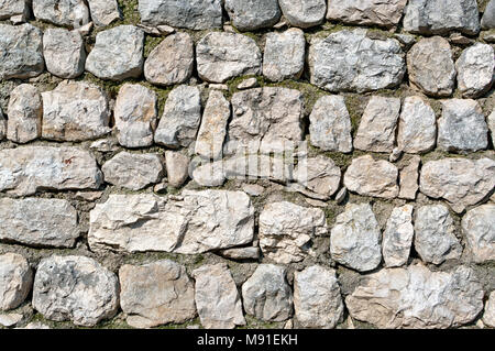 Old white and grey stones wall texture. Abstract grunge uneven bricks and concrete background. Multicolored stones and bricks rock pattern Stock Photo