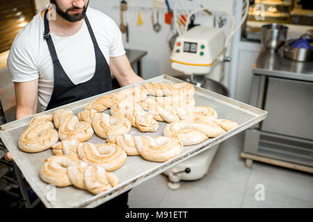 Baker with tray full of sweet pastry Stock Photo