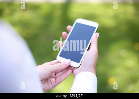 Woman using mobile smart phone in park. Stock Photo