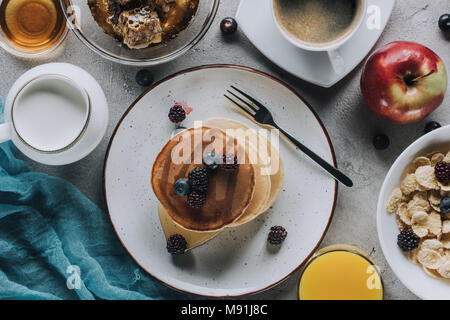 top view of tasty healthy breakfast with pancakes, fruits and granola on grey  Stock Photo