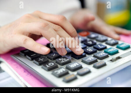 Close-up of woman using calculator. Ho Chi Minh City. Vietnam. Stock Photo