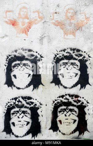 Stenciled image of Jesus Christ and monkeys wearing a crown of thorns, on a wall. Caricature.  Hanoi. Vietnam. Stock Photo