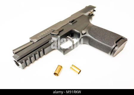 Unloaded handgun with ammo rounds on isolated background Stock Photo