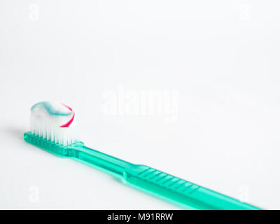 The green toothbrush with a red blue and white striped toothpaste Stock Photo
