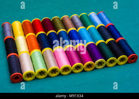 Multicolor sewing threads on background Colored threads in reels. Stock Photo
