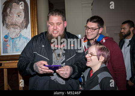 Brit award-winning singer-songwriter Rag 'n ' Bone Man (Rory Graham) struggles to operate an unfamiliar smartphone when he's asked by two young musicians for a selfie at St Paul's, a venue in Worthing, West Sussex, UK. Rag 'n' Bone Man was attending an event at the venue aimed at bringing together young musicians, venues and producers in the town. Stock Photo