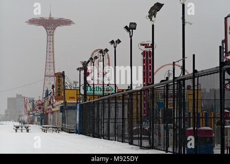 New York, New York, USA 21st March 2018. Snow covers Coney Island's famous boardwalk as he fourth 'Nor'easter' storm this month strikes the East Coast of the United States with heavy snow and wind.  Attractions on Coney Island are scheduled to open for spring on Saturday. Credit: Joseph Reid/Alamy Live News Stock Photo