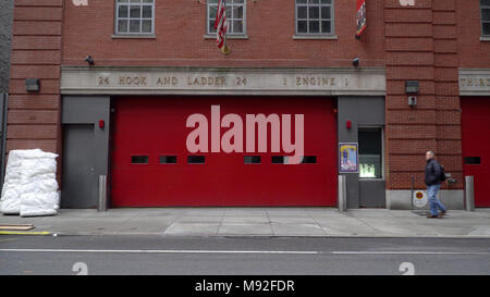 New York City, Circa 2018: Establishing shot of NYC fire department FDNY hook and ladder engine company house. View from street outside red garage Stock Photo