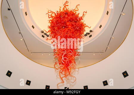 Giant hand blown, coral colored, glass sculpture hanging in the ceiling of  Artis-Naples - home of the Naples Philharmonic, Naples, Florida, USA Stock Photo