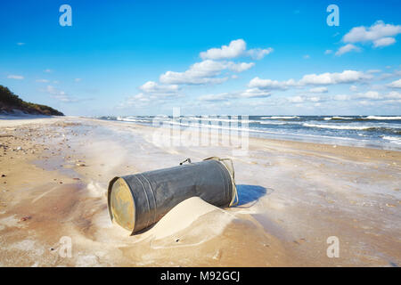 Old trash can on a beach, environmental pollution concept. Stock Photo