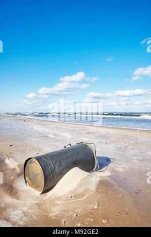 Old trash can on a beach, environmental pollution concept. Stock Photo