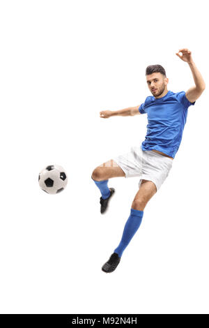 Male soccer player kicking a football in mid-air isolated on white background Stock Photo