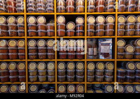 a large quantity of spices on display on a big rack at a spice and herb store or stall at borough market in central london. cookery flavours patterns. Stock Photo