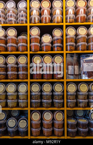 spices in jars on rows in a shop. colourful cooking spices on display. Stock Photo