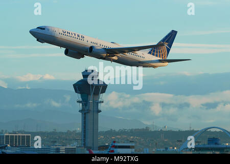 United Airlines Boeing 737-900 Jet Airliner Taking Off From Los Angeles International Airport, LAX. The Control Tower And San Gabriel Mountains Behind Stock Photo