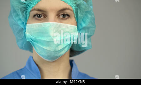 Woman doctor in protective mask blue uniform, first medical aid, occupation Stock Photo