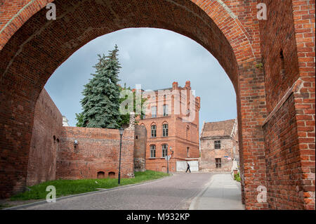 View through the arched entry of the Bridge Gate to Torun old town, Poland. Ancient, medieval gate, erected in 1432, part of the city wall. Stock Photo