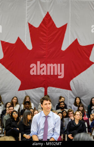 Justin Trudeau, Prime Minister of Canada, listening to questions at a town hall meeting in London, Ontario, Canada, with the Canadian flag in the back
