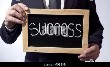 Success written on blackboard, businessman holding sign, business concept Stock Photo