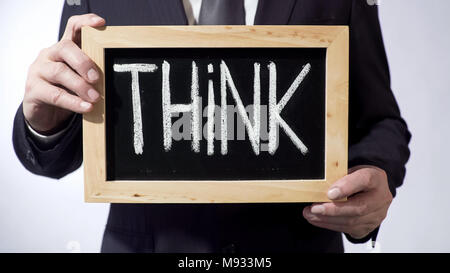 Think written on blackboard, male in classic suit holding sign, motivation, tips Stock Photo