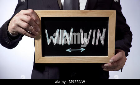 Win-Win written on blackboard, businessman holding sign, business concept Stock Photo