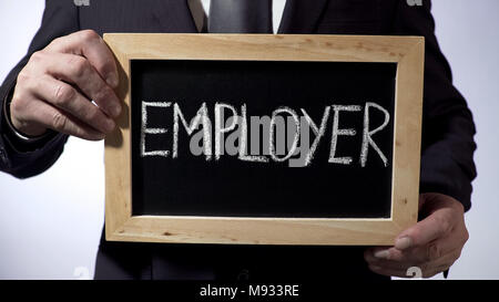 Employer written on blackboard, businessman holding sign, employment, business Stock Photo
