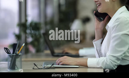 Happy young lady receiving phone call at office, talking with smile on face Stock Photo