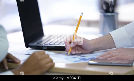 Two women making notes and discussing project, effective teamwork at office Stock Photo
