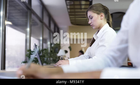 Business people working at office, attractive woman typing report on laptop Stock Photo