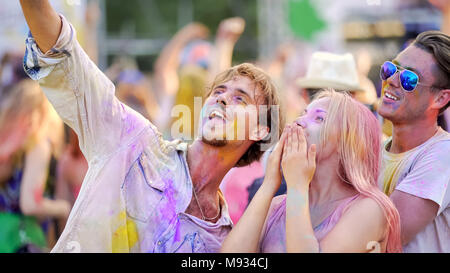 Young people making selfie on smartphone, video of color festival, friendship Stock Photo