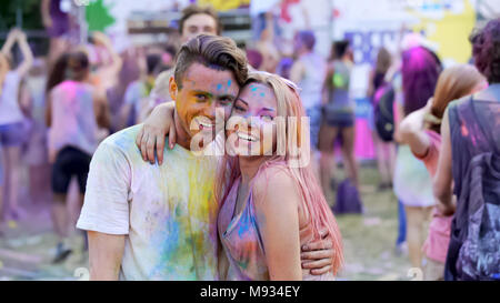 Happy friends hanging out at festival, romantic couple hugging, enjoying party Stock Photo
