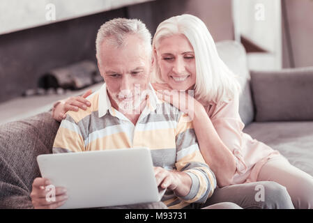 Satisfied pleasant woman smiling and leaning on her husband. Stock Photo