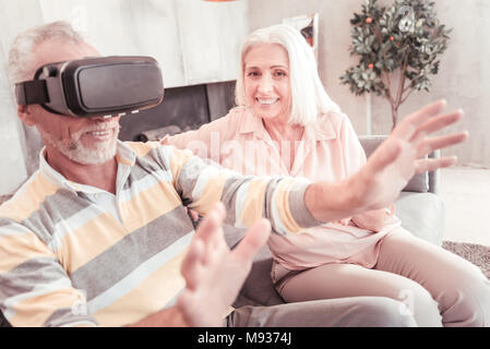 Surprised stunned man using gadget holding in front of himself. Stock Photo