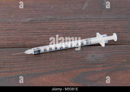 Empty syringe on a dark wooden table Stock Photo