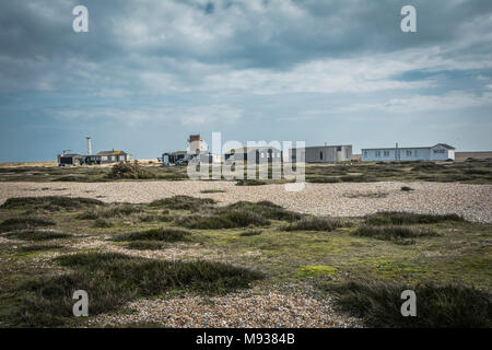 Buildings on a windswept Dungeness beach, Kent, England, UK Stock Photo