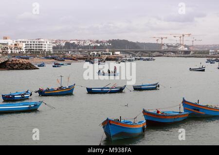 Brightly Coloured Wooden Fishing Boats on the Bou Regreg which separates Rabat and Sale in Morocco, with the Hassan 2 Bridge behind. Stock Photo