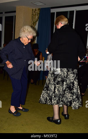 Senior women dancing with younger woman Stock Photo