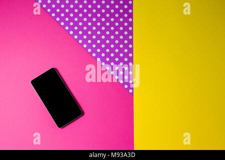 Smart phone lying on colorful background, top view. Stock Photo