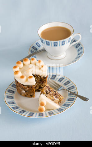Homebaked miniature Simnel cake and a cup of tea. Stock Photo