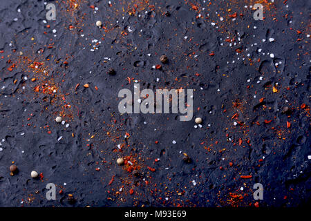 Red spices, salt and pepper on black marble. Black abstract background. Top view. Stock Photo
