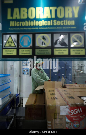 Klaten, Indonesia. 20th Mar, 2018. A worker inspects milk in laboratory at milk processing plant owned by PT Sarihusada Generasi Mahardhika, a subsidiary of Danone Group at Kemudo, Klaten, Indonesia. It is one of the biggest Danone factory in Asia that produce growing up formula milk for children, with production capacity up to 100.000 tons per years. Credit: Dadang Trimulyanto/Pacific Press/Alamy Live News Stock Photo