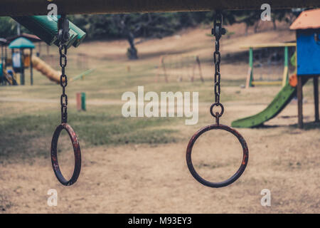rings hanging on climbing frame - vintage outdoor playground - Stock Photo