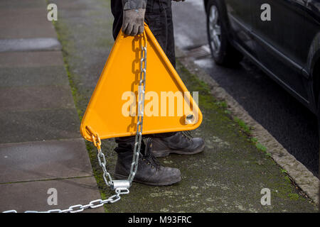 Wheel clamping of untaxed vehicles is becoming more common with the paper tax disc display being abolished and car tax needing to be paid online. Stock Photo