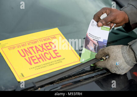 Wheel clamping of untaxed vehicles is becoming more common with the paper tax disc display being abolished and car tax needing to be paid online. Stock Photo