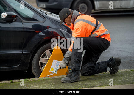 Wheel clamping of untaxed vehicles is becoming more common with the paper tax disc display being abolished and car tax needing to be paid online. Stock Photo