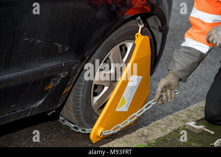 Wheel clamping of untaxed vehicles is becoming more common with the paper tax disc display being abolished and car tax needing to be paid online. Stock Photo